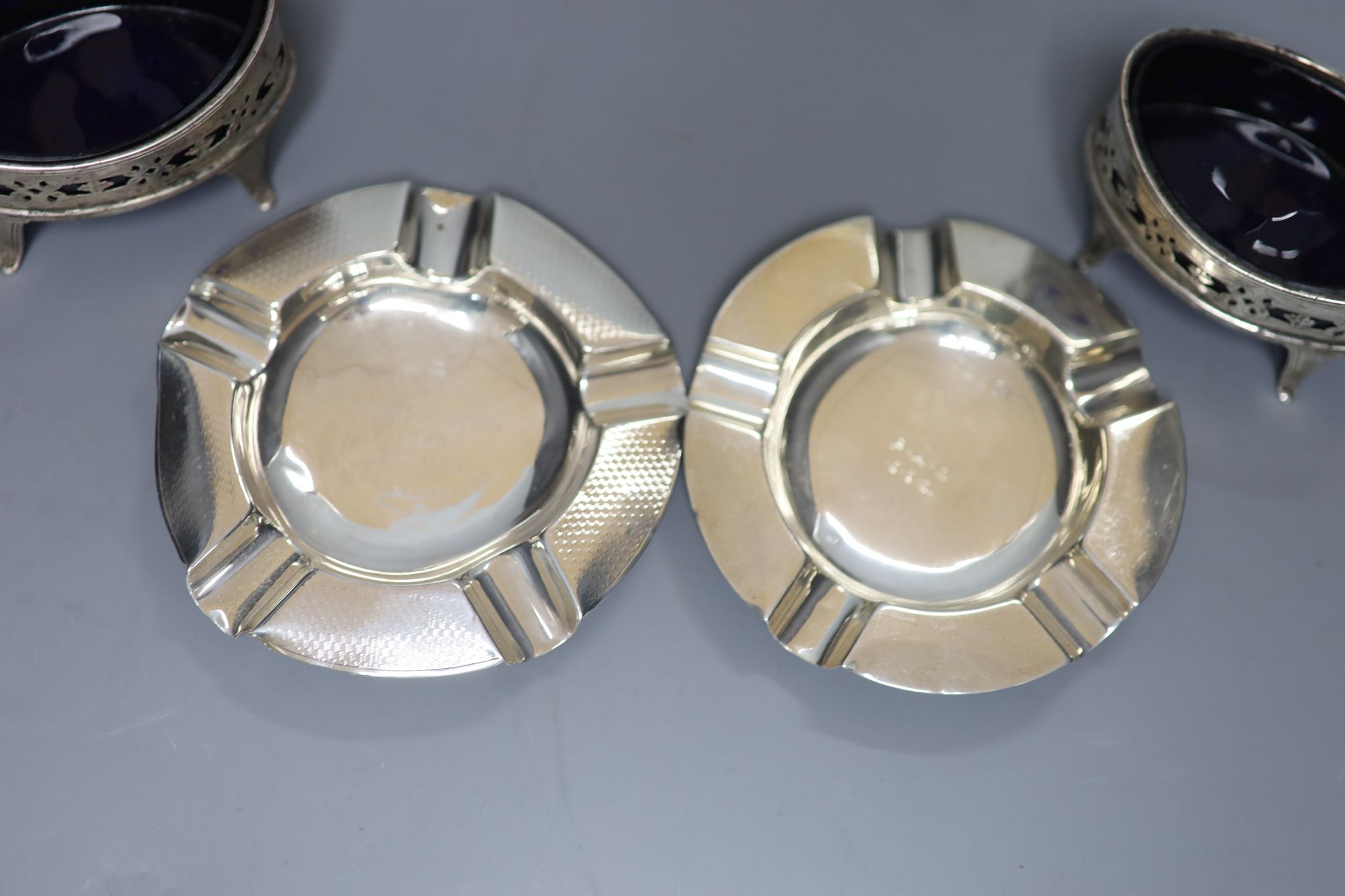 A pair of Victorian pierced silver navette shaped salts, London, 1896 and two later silver ashtrays.   ashtrays